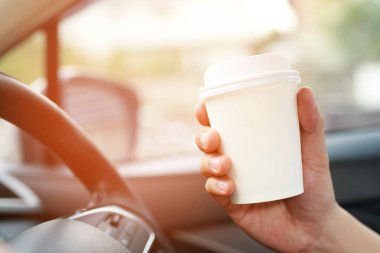 kişi kişi iş adamı sabah güneş ışığında bir arabada sürüş sırasında elinde sıcak kağıt fincan kahve içme .ulaşım ve araç kavramı. 