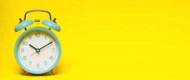 Klasik retro alarm saati saat dört yönünde, sarı arka planda on dakika.. 