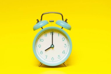 Klasik antika çalar saat. Sarı arka planda 12 'ye 8 var.. 