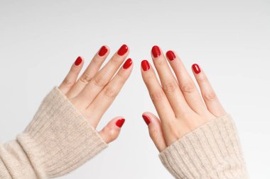 Güzel kadın eli akrilik jel kırmızısı tırnakları boyuyor. Moda tarzı.
