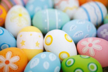 Paskalya ve baharı kutlamak için yeşil çimlerde renkli paskalya yumurtaları koleksiyonu..