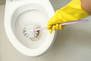 Housewives use a brush to clean the bathroom to remove dirt and take care of sanitary ware.	