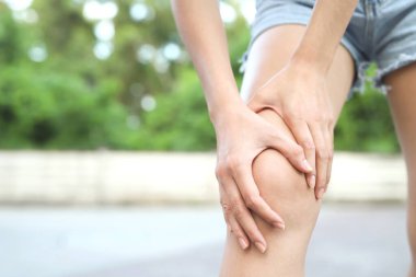 female touching painful twisted or broken ankle. Athlete training accident. Sport sprain cause injury knee leg bones while run in outdoor the park.	