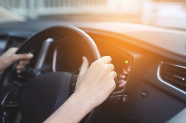 Close up of hands hold steering wheel young woman driving a car riding on the road. driver trip of travel.	