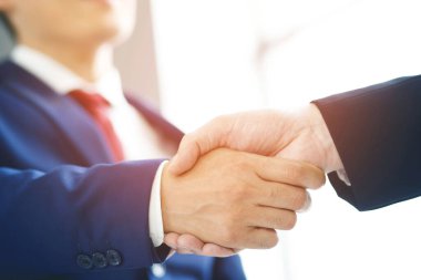 Closeup of a businessman hand shake businesswoman between two colleagues OK, succeed in business Holding hands.	