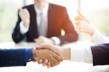 Closeup of a businessman hand shake businesswoman between two colleagues OK, succeed in business Holding hands.	