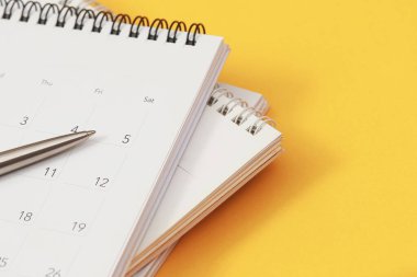 Sarı arkaplanda takvimi olan bir kalem