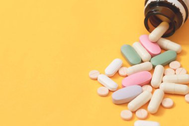 İlaç şişesi dökülüyor. Yüzey tabletlerine renkli haplar 