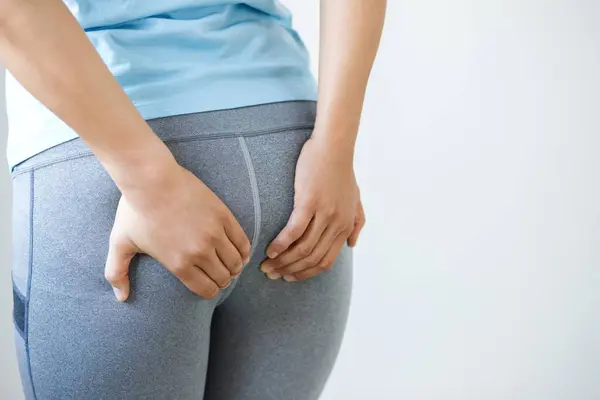 stock image concept of health problems woman has hemorrhoids