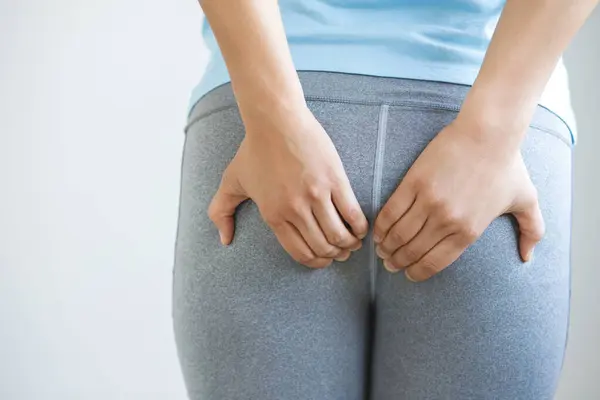 stock image concept of health problems woman has hemorrhoids