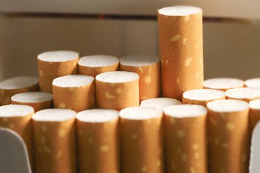 Sigara paketini sıyır, beyaz ahşap arka planda sigara iç. Paketleme sırası. fotoğraf filtreleri Doğal ışık