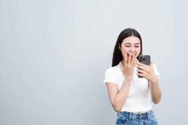 Model Asyalı kadın duyguları cep telefonlarında online piyango biletleriyle ödül kazanmaktan mutlu ve heyecanlı..