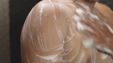 Adam banyoda anti bakteriyel duş jeliyle duş alıyor.