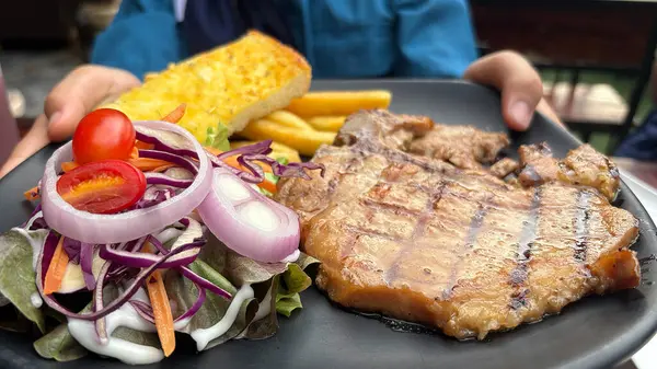 Akşam yemeğinde sebze salatası ve domuz eti.