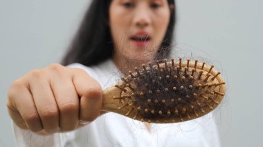 Saç dökülmüş, kuru ve kıvırcık saçlı bir kadın.