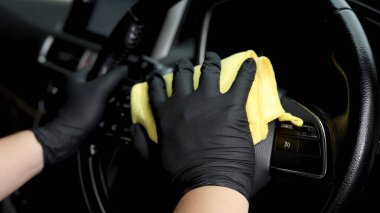 Personel araba bakım dükkanında arabaları temizlemek için mikrofiber bez kullanıyor..