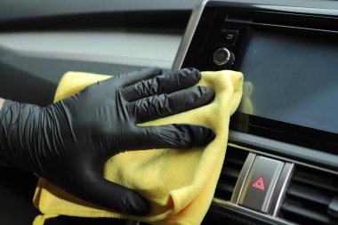 Personel araba bakım dükkanında arabaları temizlemek için mikrofiber bez kullanıyor..