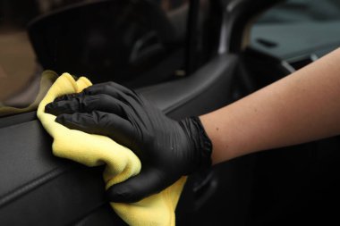 Personel araba bakım dükkanında arabaları temizlemek için mikrofiber bez kullanıyor..