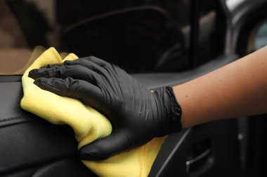 Personel araba bakım dükkanında arabaları temizlemek için mikrofiber bez kullanıyor..