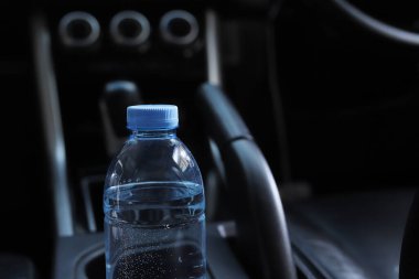 Arabada bir şişe su var.