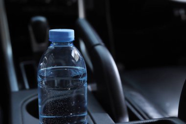 Arabada bir şişe su var.
