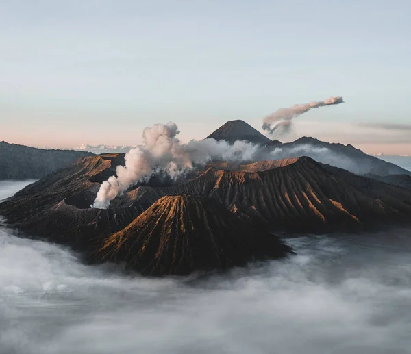 印度尼西亚东爪哇Bromo Tengger Semeru国家公园的Gunung Bromo火山 带着柔和的灯光和浓烟的日出 Semeru在背景中爆发 照片来自印度尼西亚 — 图库照片