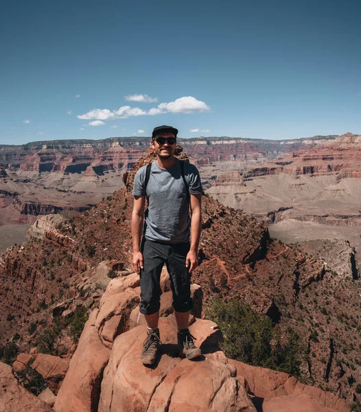 グランドキャニオンの前に立つ若い男のズボン バックパック付きのハイカーはアメリカ 景色を楽しんでいます 旅行とアウトドアの概念 アメリカ合衆国国立公園 アメリカで撮影した写真 — ストック写真