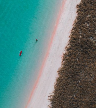 Woman walking and enjoying empty paradise tropical beach. Nobody around. Aerial view of Padar island Pink Beach. Vertical photo