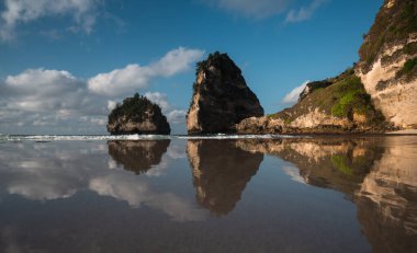 Muhteşem Elmas Sahili manzarası güzel bir gündoğumu sırasında turkuaz bir deniz tarafından yıkandı. Diamond Beach, Nusa Penida 'nın doğu ucunda el değmemiş, beyaz kumlu ve ipeksi mavi bir su koyudur.