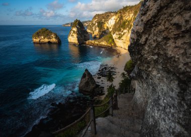 Muhteşem Elmas Sahili manzarası güzel bir gündoğumu sırasında turkuaz bir deniz tarafından yıkandı. Diamond Beach, Nusa Penida 'nın doğu ucunda el değmemiş, beyaz kumlu ve ipeksi mavi bir su koyudur.