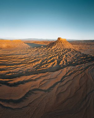 Utah 'ın Caineville Çorak Toprakları' ndaki Fabrika Butte. Güneş doğarken hava aracı panoraması