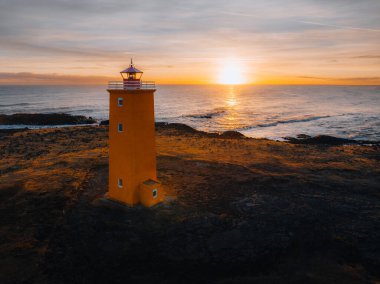İzlanda 'nın deniz kıyısındaki turuncu deniz fenerinin insansız hava aracı fotoğrafı. Batı İzlanda kıyıları ve yaz mevsiminde Snaefellsnes Yarımadası 'ndaki deniz feneri. İzlanda seyahati