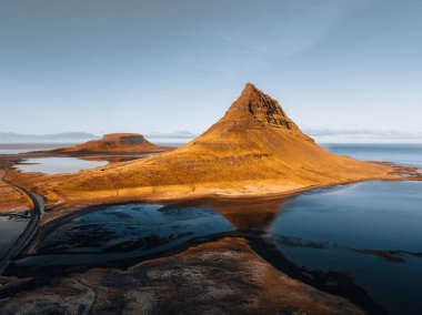 İzlanda 'nın Snaefellsnes yarımadasındaki Kirkjufell yüksek dağının güzel hava manzarası. Gün batımı yumuşak turuncu ışık. Batı İzlanda