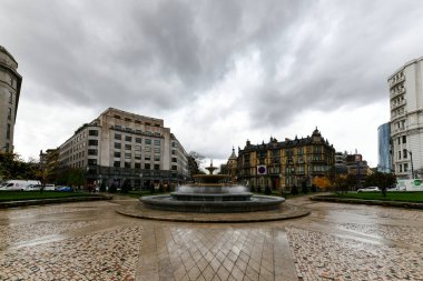 Bilbao, İspanya - 26 Kasım 2021: Kent merkezinde Plaza de Federico Moyua veya Elliptical Square, İngiliz ve Fransız tarzı çiçek yatakları, modern çelik lamba direği ve mobilyaları ile.