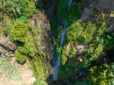 Madeira adasındaki Angels şelalesinin (Cascata dos Anjos) insansız hava aracı görüntüsü. Şelale kayalıkların üzerinden bölgesel yola dökülüyor ve aşağıdaki denize dökülüyor..