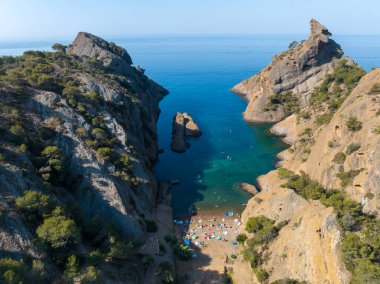 Calanque de Figuerolles 'in havadan görünüşü, Fransa' daki engebeli kayalıkların çerçevelediği rahat bir koy..