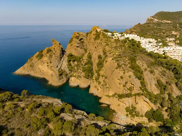 Calanque de Figuerolles 'in havadan görünüşü, Fransa' daki engebeli kayalıkların çerçevelediği rahat bir koy..