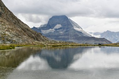 İsviçre 'nin Zermatt kentindeki ünlü Matterhorn dağı ihtişamını nazikçe Riffelsee' nin sakin sularında yansıtıyor. Alp manzarası nefes kesici. Güzel manzara.