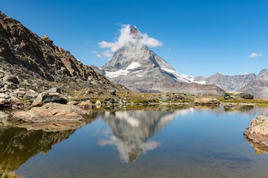 İsviçre 'nin Zermatt kentindeki ünlü Matterhorn dağı sakin yaz manzarası Riffelsee' nin sakin sularında ihtişamını nazikçe yansıtır. Alp manzarası nefes kesici. Güzel manzara.