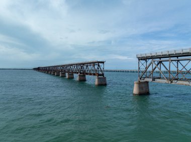 Güneşli bir günde Bahia Honda Demiryolu Köprüsü 'nün havadan görünüşü. Bahia Honda Demiryolu Köprüsü, Florida Keys 'te Bahia Honda Key' i İspanyol Limanı Anahtarı 'na bağlayan terk edilmiş bir demiryolu köprüsü.