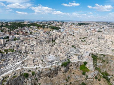Matera 'nın (Sassi di Matera) güney İtalya' daki güzel Basilicata kentinin havadan görünüşü. Eski mağara evleri derin vadideki tufa kayasına oyulmuş, Gravina Nehri..