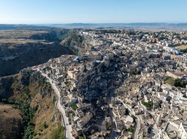 Matera 'nın (Sassi di Matera) güney İtalya' daki güzel Basilicata kentinin havadan görünüşü. Eski mağara evleri derin vadideki tufa kayasına oyulmuş, Gravina Nehri..