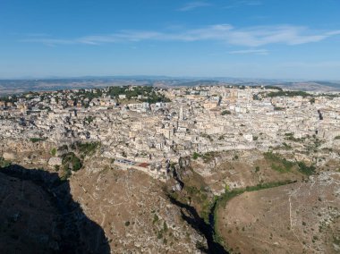Matera 'nın (Sassi di Matera) güney İtalya' daki güzel Basilicata kentinin havadan görünüşü. Eski mağara evleri derin vadideki tufa kayasına oyulmuş, Gravina Nehri..