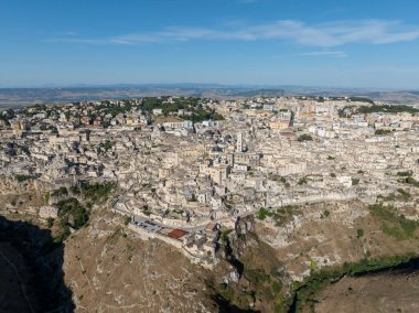 Matera 'nın (Sassi di Matera) güney İtalya' daki güzel Basilicata kentinin havadan görünüşü. Eski mağara evleri derin vadideki tufa kayasına oyulmuş, Gravina Nehri..