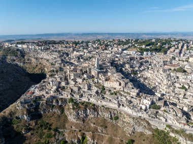 Matera 'nın (Sassi di Matera) güney İtalya' daki güzel Basilicata kentinin havadan görünüşü. Eski mağara evleri derin vadideki tufa kayasına oyulmuş, Gravina Nehri..