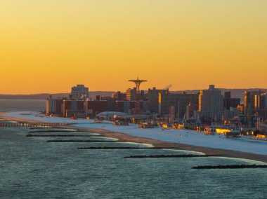 Brooklyn, New York 'ta kış günbatımında Coney Island Sahili' ni kaplayan kar manzarası