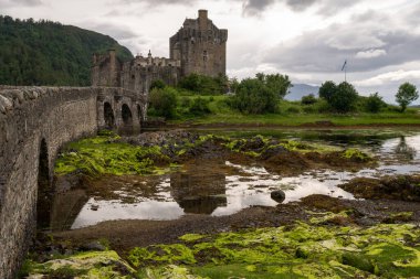 Eilean Donan castle with connecting footbridge on a tidal island between Loch Duich, Loch Long and Loch Alsh in Highlands of Scotland, near Dornie, UK clipart