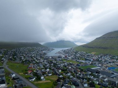 Beautiful aerial view of the City of Klaksvik in the Fareo Islands with its colorful houses and amazing canal and view to the majestic Kunoy Park clipart