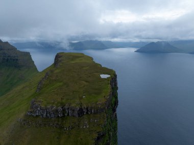 Danimarka 'nın Faroe Adaları' ndaki Kallur deniz fenerinin yanındaki tepeler..