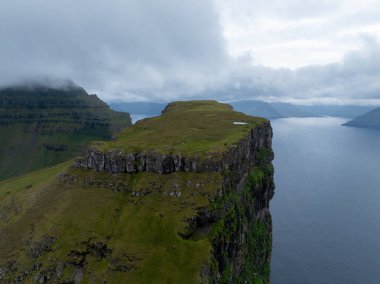 Danimarka 'nın Faroe Adaları' ndaki Kallur deniz fenerinin yanındaki tepeler..